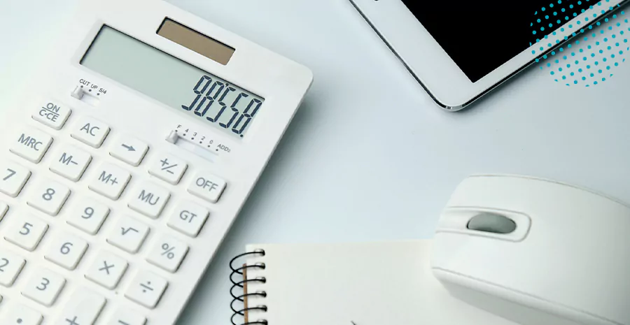 imagem de uma calculadora em cima de uma mesa ao lado de um caderno, um mouse e um celular