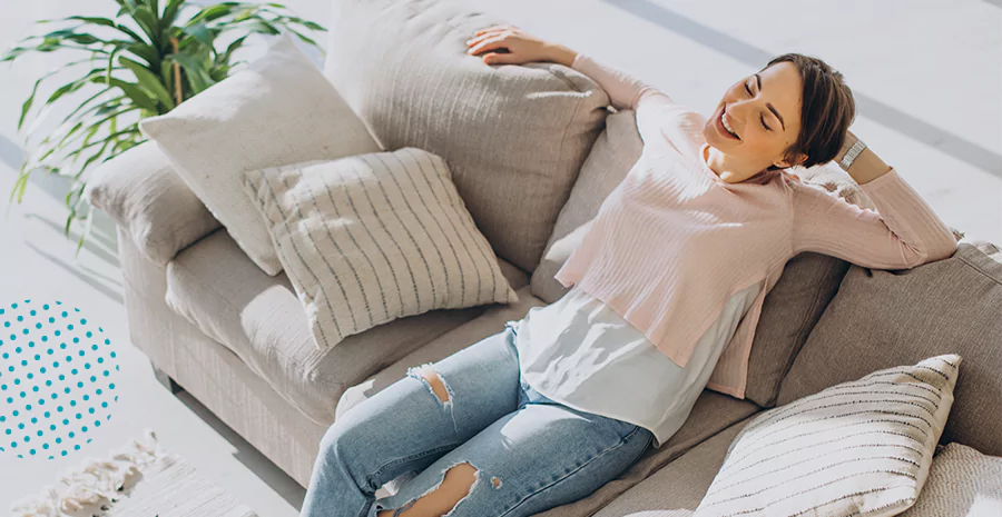 imagem de uma mulher sentada em um sofá se espreguiçando