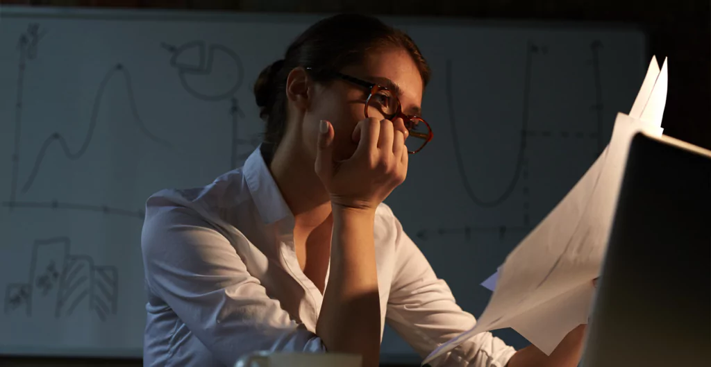 mulher segurando papel com expressão preocupada