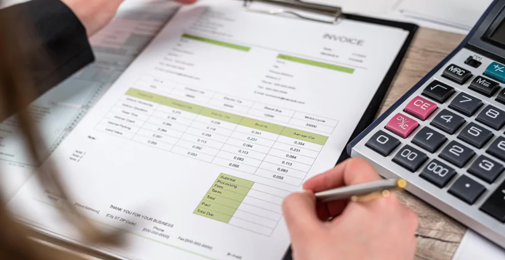 imagem de uma pessoa fazendo anotações com uma calculadora ao lado, representando a desoneração da folha de pagamento