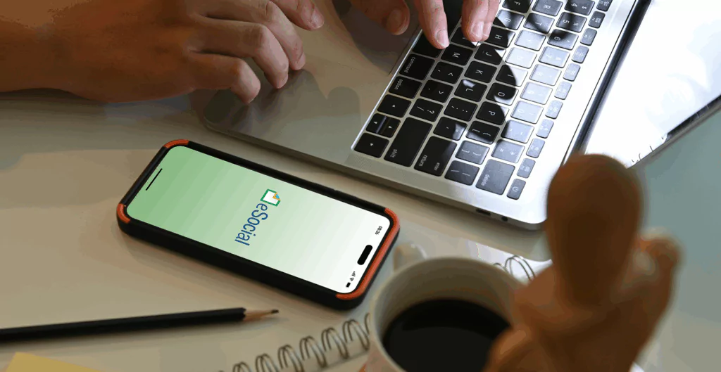 Alguém digitando em um notebook com um celular ao lado, no contexto de Qualificação cadastral eSocial.