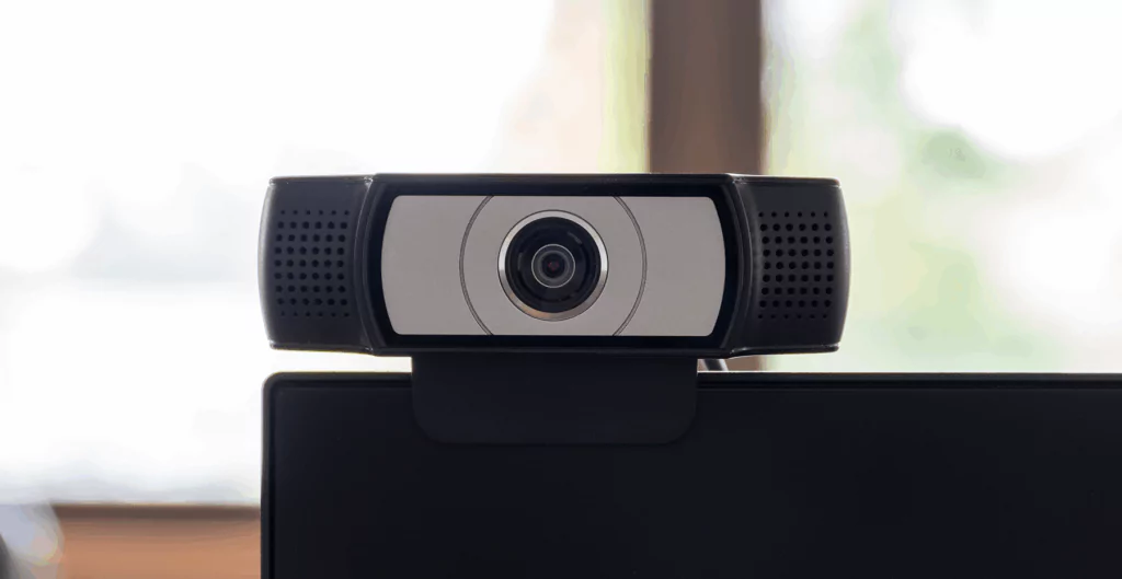 Equipamento de webcam usado como ferramenta de monitoramento no home office, com foco em segurança e transparência.